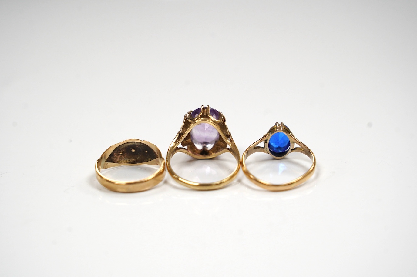 A modern 9ct gold and amethyst set dress ring, a 9ct and diamond chip set ring and a yellow metal (stamped 15c) and blue stone set ring, gross weight 8.2 grams. Condition - poor to fair